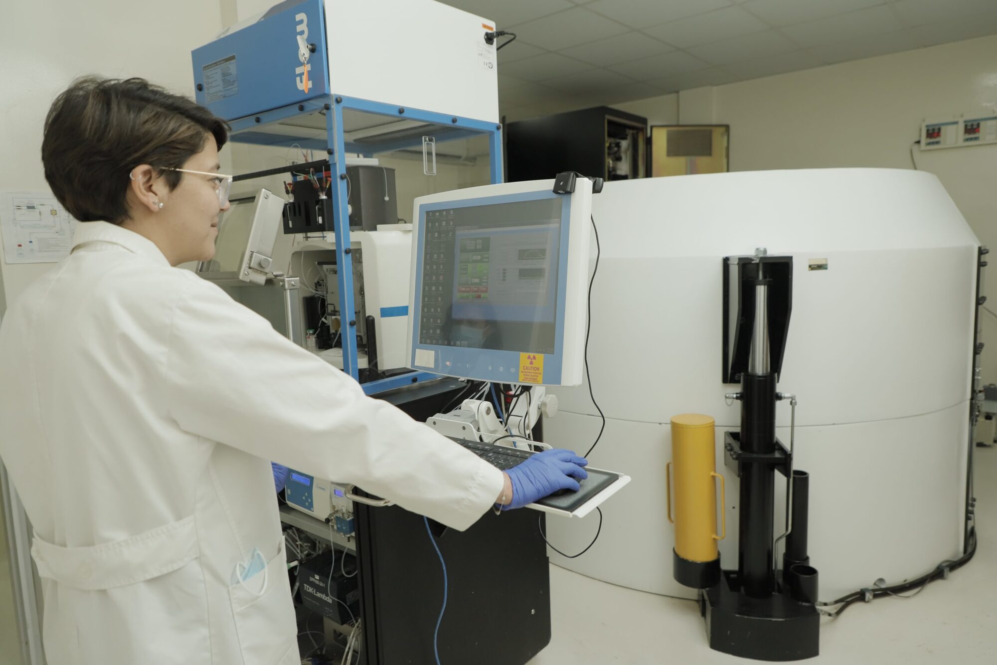 Profesional operando la consola del ciclotrón y el área de radiofarmacia de Oncoservice