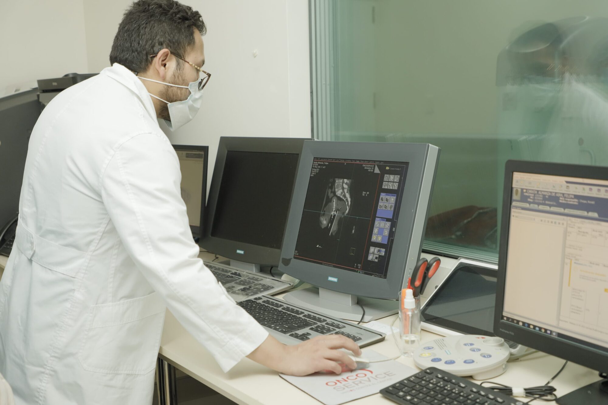 Especialista planificando un tratamiento sobre imágenes de tomografía en la consola de Oncoservice
