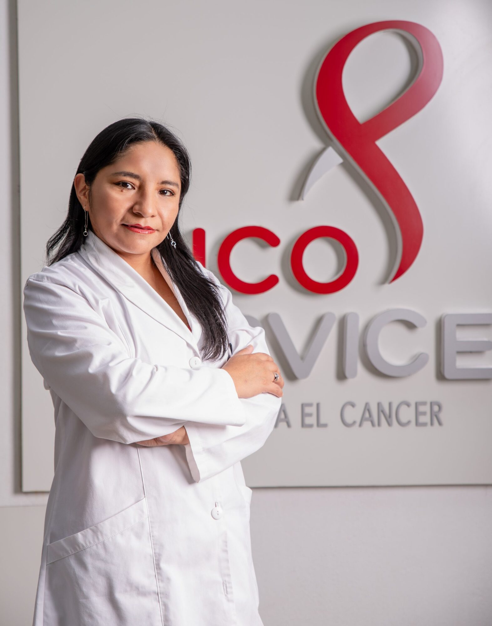 Profesional del equipo de Oncoservice frente al mural institucional
