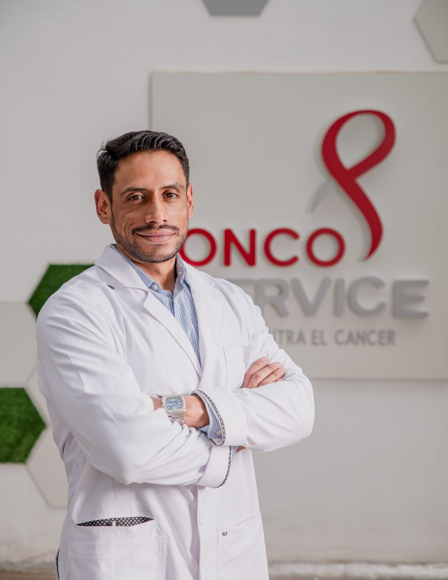 Profesional del equipo de Oncoservice frente al mural institucional
