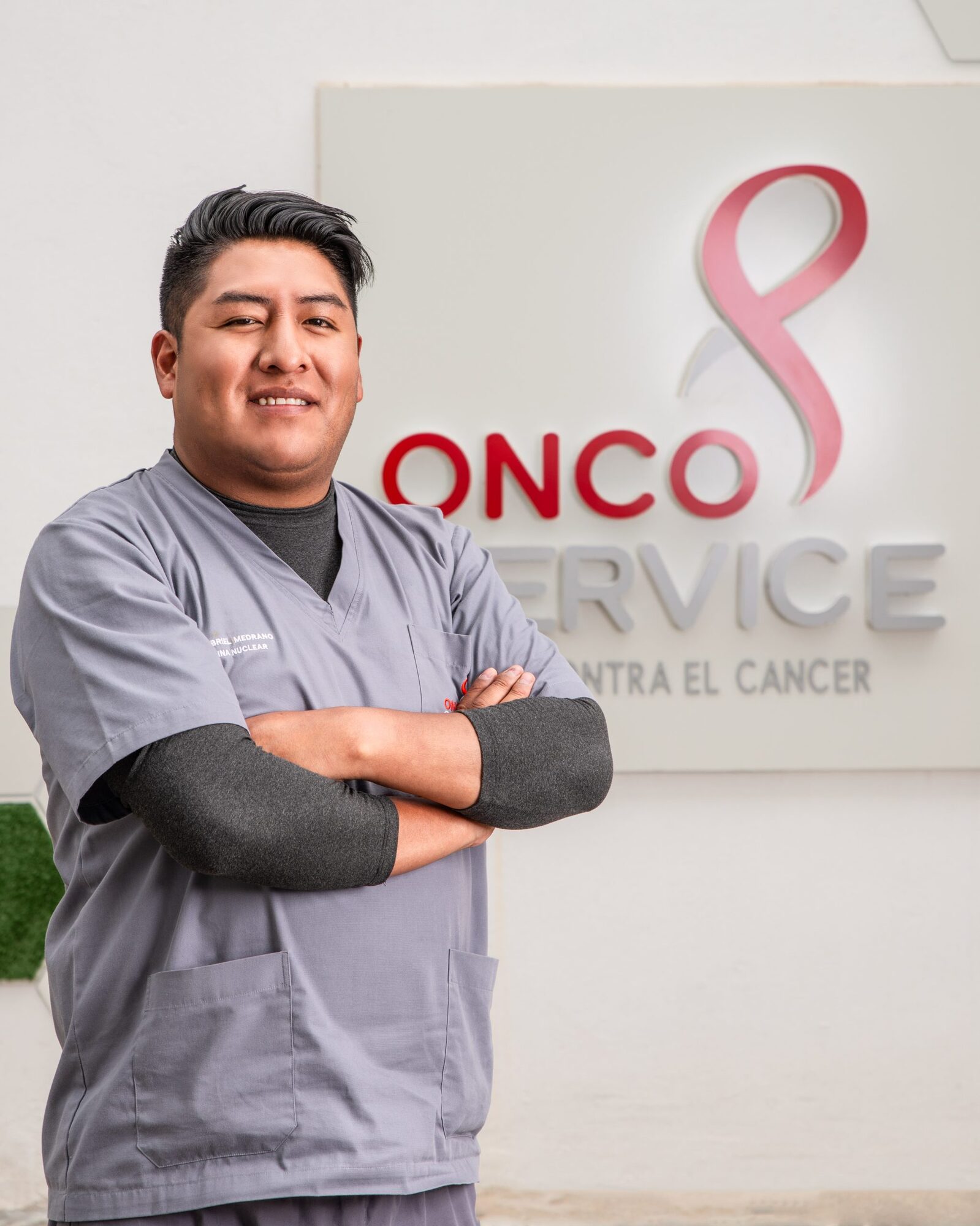 Profesional del equipo de Oncoservice frente al mural institucional