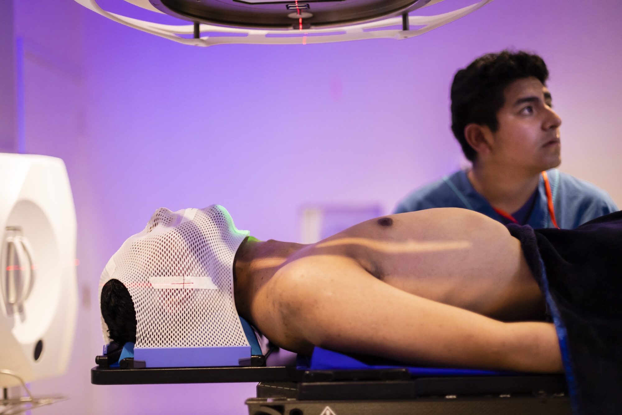 Paciente con máscara termoplástica de inmovilización durante la sesión de radioterapia